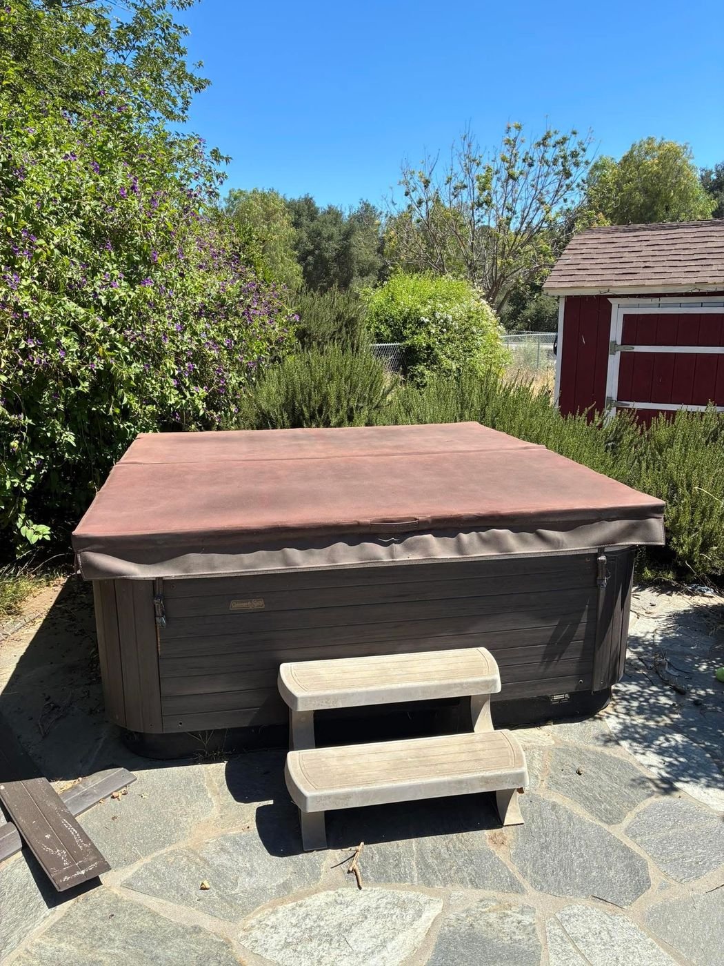 Old hot tub before removal on a flagstone patio
