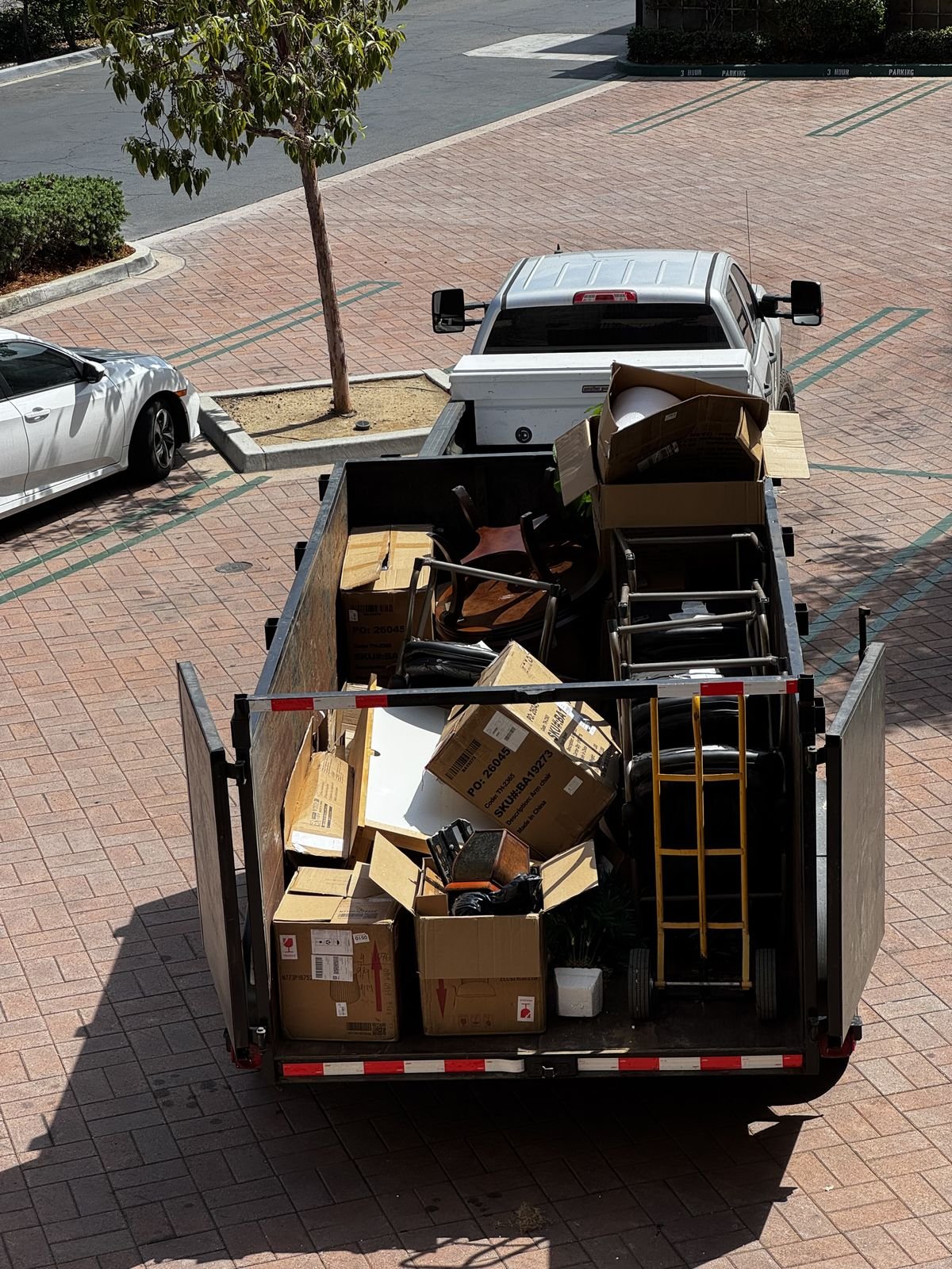 Dump trailer loaded with office furniture and boxes